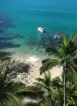 Barco ancorado em enseada de águas cristalinas